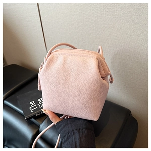 Détail du mini sac bandoulière rose clair avec design plissé et texture cuir litchi