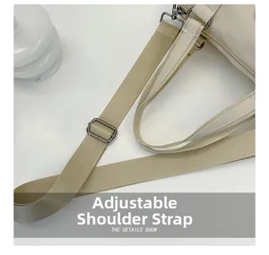 Close-up of beige nylon crossbody bag featuring an adjustable strap with metal buckle
