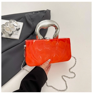 Macro detail of orange marble acrylic texture and silver metal handle on a handbag
