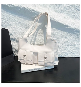 Vue détaillée du sac à bandoulière en cuir blanc avec deux poches et boucles argentées