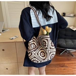 Détail d'un sac cabas au crochet fait main avec des motifs floraux marron et crème