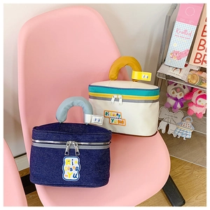 Detail of cute cottage-shaped makeup bags with fabric texture and logo embroidery