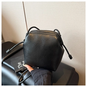 Détail de la texture du cuir litchi noir sur ce mini sac à bandoulière élégant