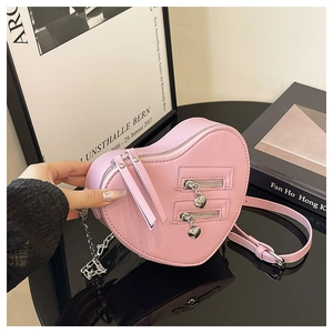 Detail of pink heart-shaped crossbody bag featuring matte PU leather and metal chain straps