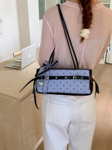 Blue aesthetic shoulder bag with heart patterns and lace bow accessory shown on model