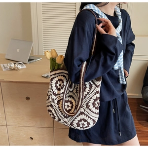Détail d'un cabas au crochet bohème avec motifs floraux tricotés et large bandoulière