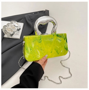 Detail view of yellow-green marble textured acrylic handbag with silver chunky handle