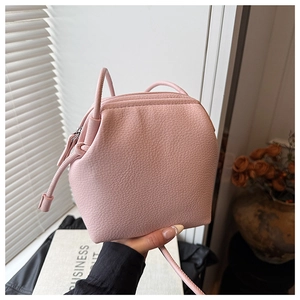 Détail du sac seau en cuir grainé rose avec cordon de serrage et finitions argentées