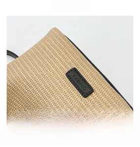 Détail de la texture en paille tressée avec bordure en cuir noir et logo C&HEKA