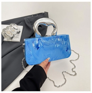 Detail view of marble texture blue square handbag with bold silver metal handle and chain