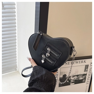 Detailed close-up of black heart-shaped PU leather crossbody bag with dual zippers
