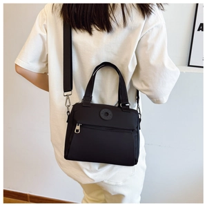 Close-up of black fabric crossbody bag with DAIOU logo and silver metal hardware