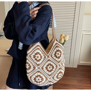 Détail d'un sac cabas au crochet bohème avec des motifs floraux sur un bureau en bois