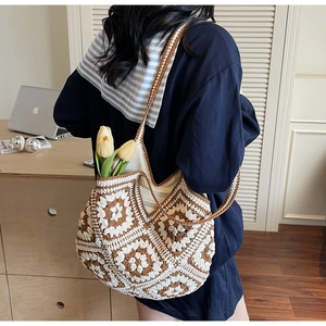 Détail d'un grand sac cabas en crochet bohème avec motifs floraux marron et blanc