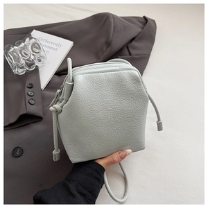 Detailed close-up of light blue pebble grain leather texture on a chic shell bag