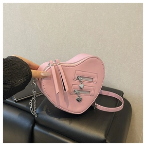 Detailed view of pink heart-shaped bag with zip accents and silver chain strap