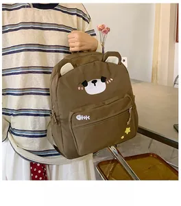 Close-up detail of cartoon brown bear canvas backpack with 3D ears and cute star embroidery