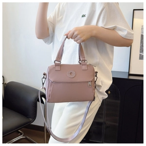 Detail of dusty pink nylon crossbody bag showing smooth texture and adjustable shoulder strap
