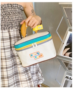 Detail of cute house-shaped cosmetic bag featuring a unique yellow banana-style handle