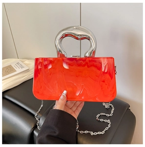 Detail of red marble acrylic bag with a fluid silver metal handle and chain strap