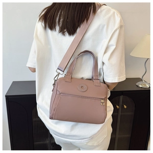 Detailed back view of a dusty pink nylon crossbody bag with wide adjustable shoulder strap