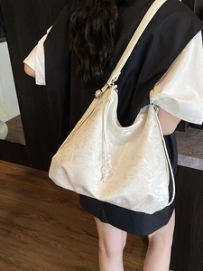 White jacquard embroidered shoulder bag with floral texture and drawstring details