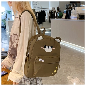 Detailed view of the bear backpack's unique ears, embroidery, and durable canvas fabric