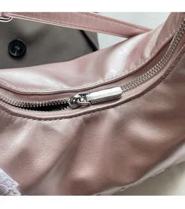 Close-up of the smooth silver zipper and pearlescent pink leather texture of the bag