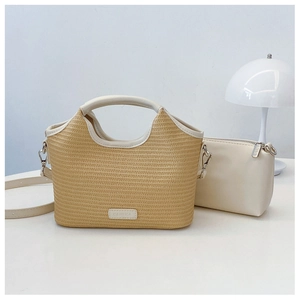 Détail d'un grand sac cabas en paille tissée avec anses en cuir blanc et pochette zippée