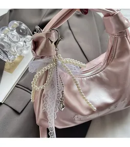 Close-up of pink wax leather handbag featuring fashion embossing and pearl lace charm
