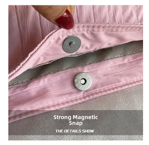 Detail view of pink pleated canvas bag showing silver magnetic closure and herringbone lining