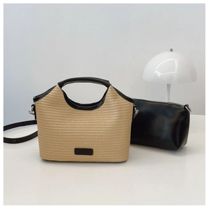 Détail du sac cabas en paille tissée avec bordure en cuir noir, pochette et bandoulière