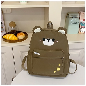 Detailed view of brown cartoon bear backpack on a white desk in a cozy room setting