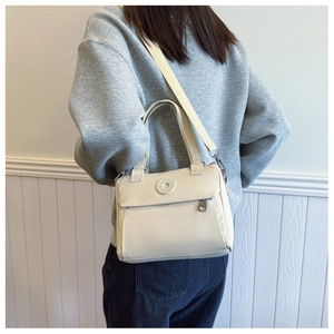 Detail view of cream white nylon shoulder bag with DAIOU logo and silver metal hardware