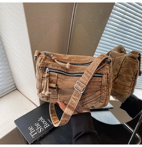 Detail showing vintage washed denim texture and functional silver zippers of the crossbody bag
