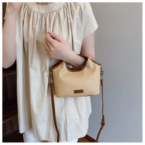 Détail du sac bandoulière demi-lune en paille avec bordure cuir et étiquette OSHINA