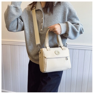 Beige nylon crossbody bag detail with adjustable shoulder strap and round logo