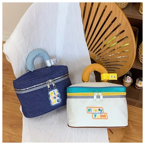 Detail of cute house-shaped makeup bags with colorful letter patches and handles