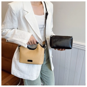 Détail d'un ensemble cabas en paille tressée et pochette en cuir avec tenue décontractée