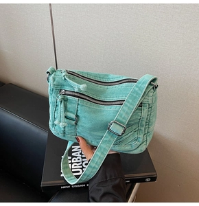 Detail of mint green denim crossbody bag showing multi-pocket design and adjustable strap