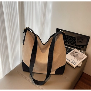 Detail of canvas tote bag with black trim and metal buckle in a lifestyle setting