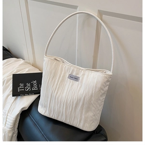 Detailed view of the white pleated fabric texture and Ann's then brand label on the bag