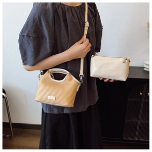 Détail du sac à main en paille tissée et pochette en cuir blanc avec bandoulière