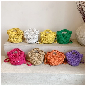 Close-up of handmade crochet bucket bags in eight vibrant colors on stone steps
