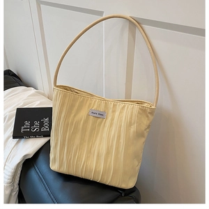 Detail of yellow pleated canvas tote with Ann's then logo and slim tubular strap