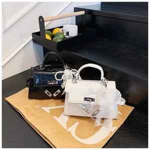 Detail of mini crocodile pattern handbags with pearl lace charms and silver twist locks