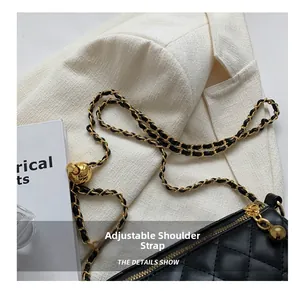 Détail de la bandoulière réglable sur sac bandoulière matelassé noir avec accents dorés