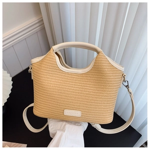 Détail de la texture en paille tressée et du logo en cuir sur un sac beige
