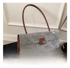 Gros plan du sac à bandoulière en jacquard gris avec motifs floraux et étiquette
