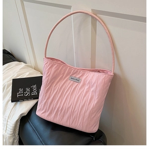 Detail showing pink pleated canvas fabric texture and silver logo on a shoulder tote bag